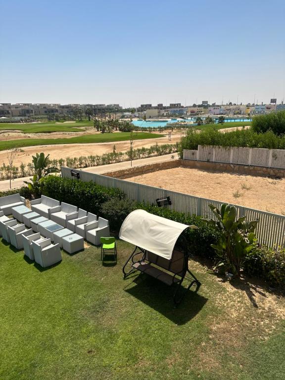 a table and chairs with a white cover on a lawn at Hacienda Bay, North Coast in El Alamein