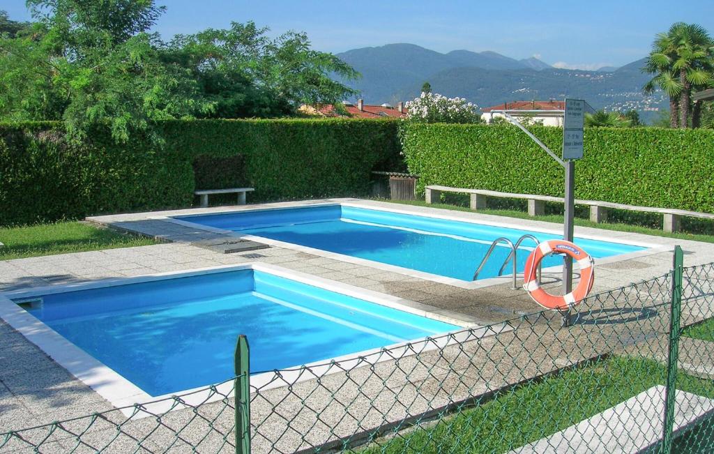 a blue swimming pool with a fence around it at Awesome Apartment In Germignaga va With Outdoor Swimming Pool in Germignaga