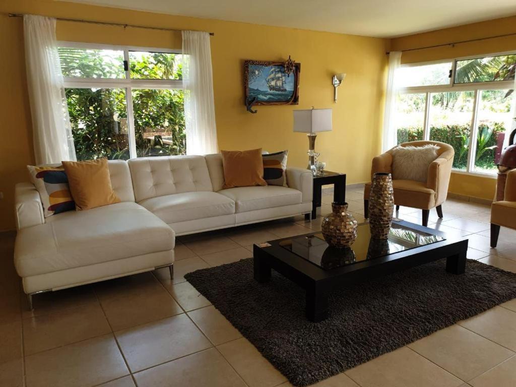 uma sala de estar com um sofá branco e uma mesa de centro em Little paradise em Tela