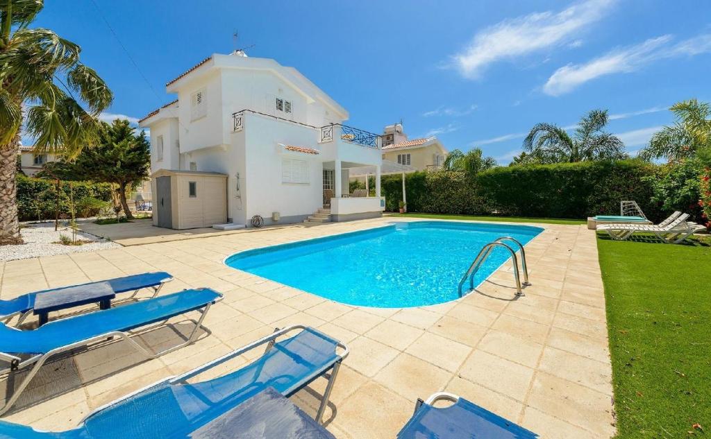 una piscina con sillas azules y una casa en Ferienhaus mit Privatpool für 6 Personen ca 180 qm in Agia Napa, Südküste von Zypern, en Ayia Napa