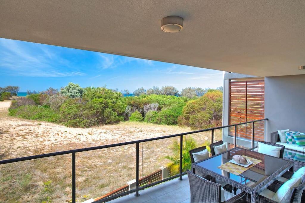a balcony with a table and chairs and a view at Loka Santi 10 - Beachfront unit in Agnes Water
