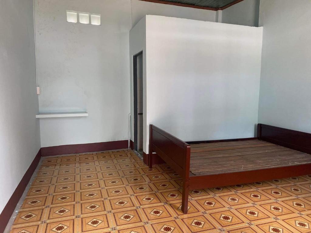a room with a bed and a wooden floor at Nhà trọ Tân An in Tân Tạo