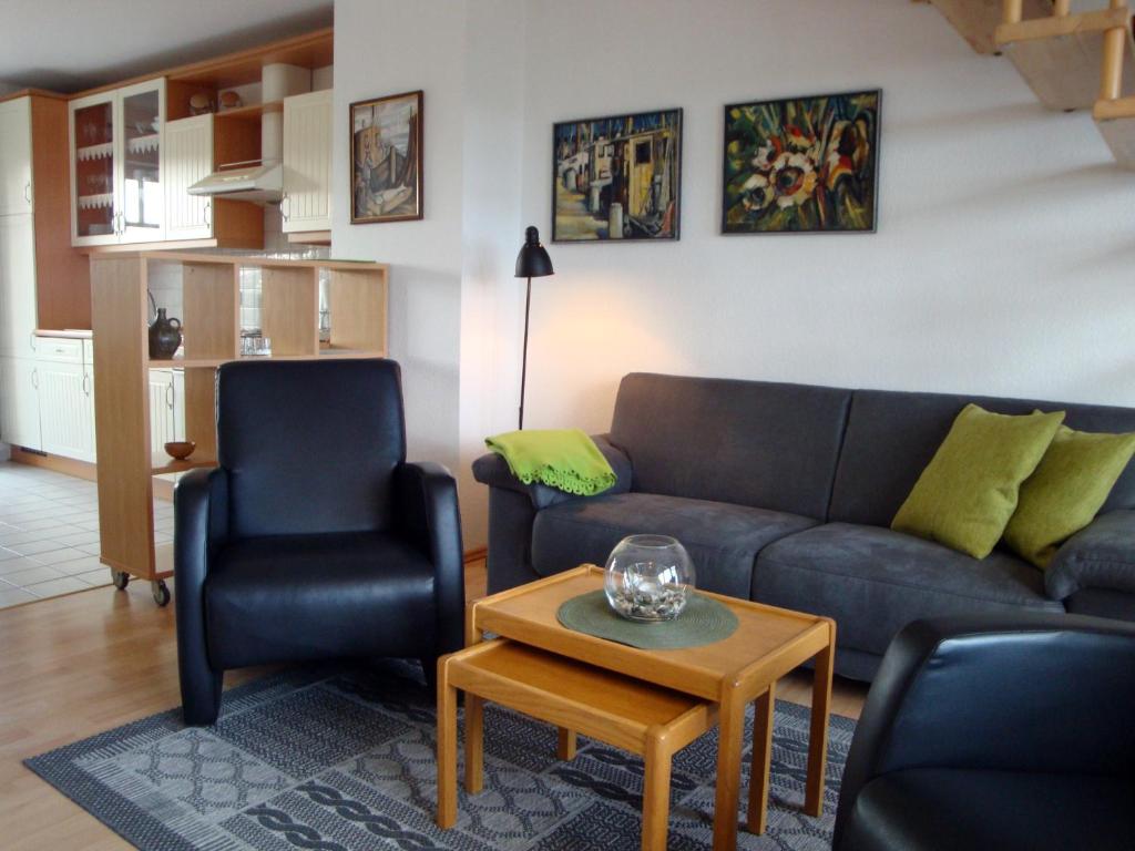 un salon avec un canapé, deux chaises et une table dans l'établissement Haus Tante Clara Skipperkoje, Whg 20, Kukshörner Weg 8b, à Dangast