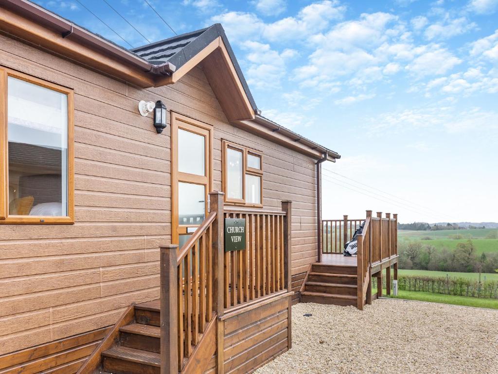 a wooden house with a porch and a deck at Church View - Uk46896 in Kinlet