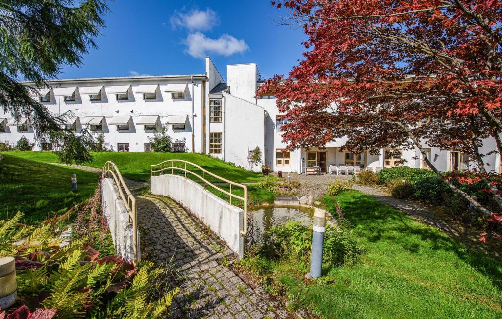 um grande edifício branco com uma cerca em frente em Stunning Apartment In Stavanger With Kitchen em Stavanger