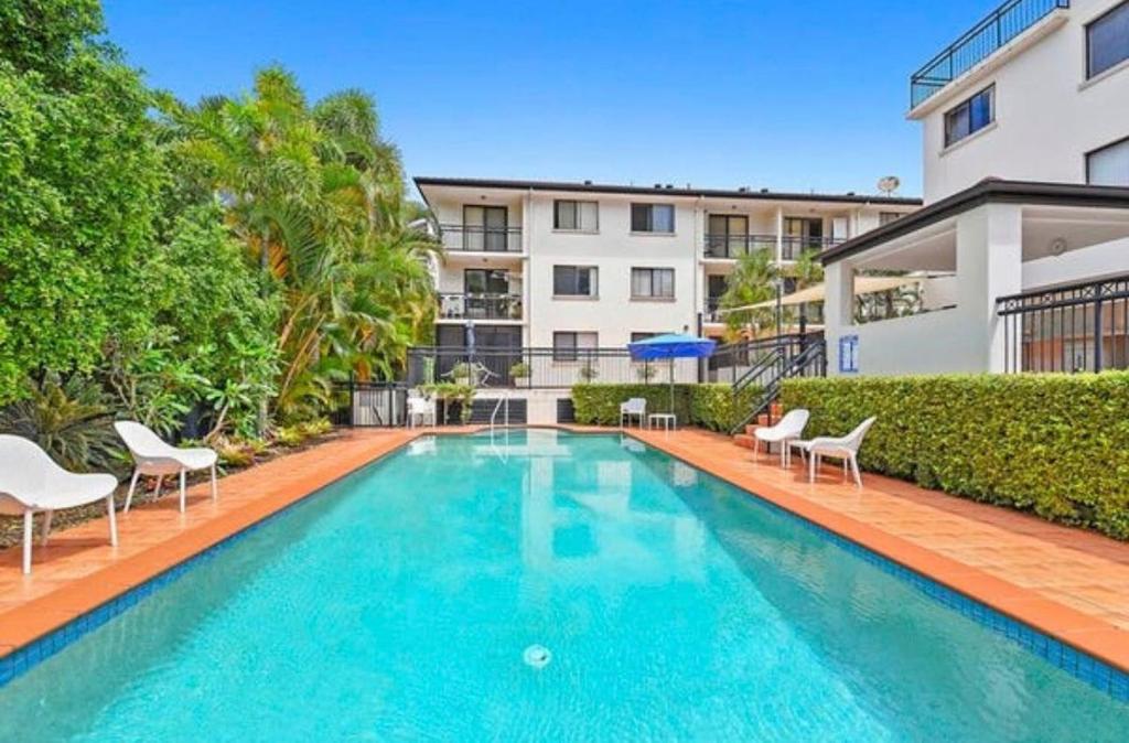 a swimming pool with chairs and a building at Seaside Oasis 2Beds Apt with Free Parking in Gold Coast