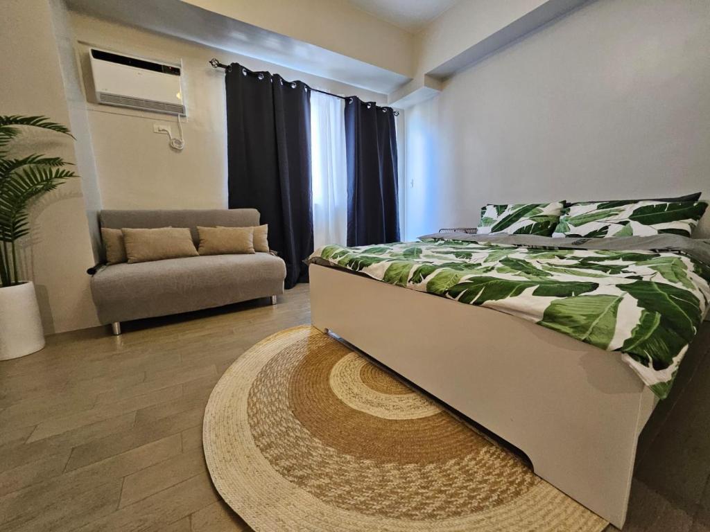 une chambre avec un lit, une chaise et un tapis dans l'établissement Brand New Central Convenience Studio Condo with Balcony in Araneta City Cubao, à Manille