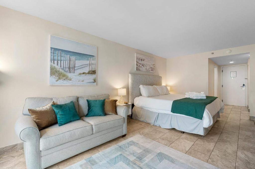 ein Schlafzimmer mit einem Bett und einer Couch in der Unterkunft Sandestin Bayfront Studio with balcony and breathtaking views in Destin