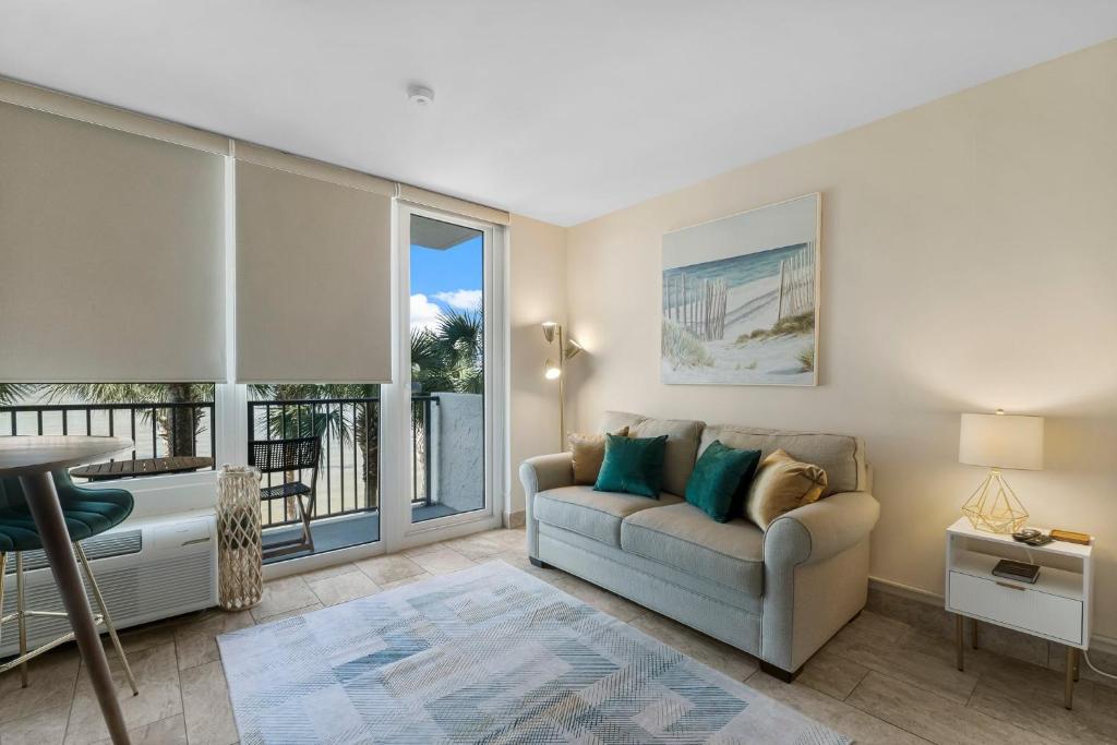 ein Wohnzimmer mit Couch und großem Fenster in der Unterkunft Sandestin Bayfront Studio with balcony and breathtaking views in Destin