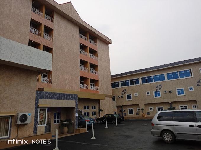 a car parked in a parking lot in front of a building at Francinesplace Hotel in Uyo