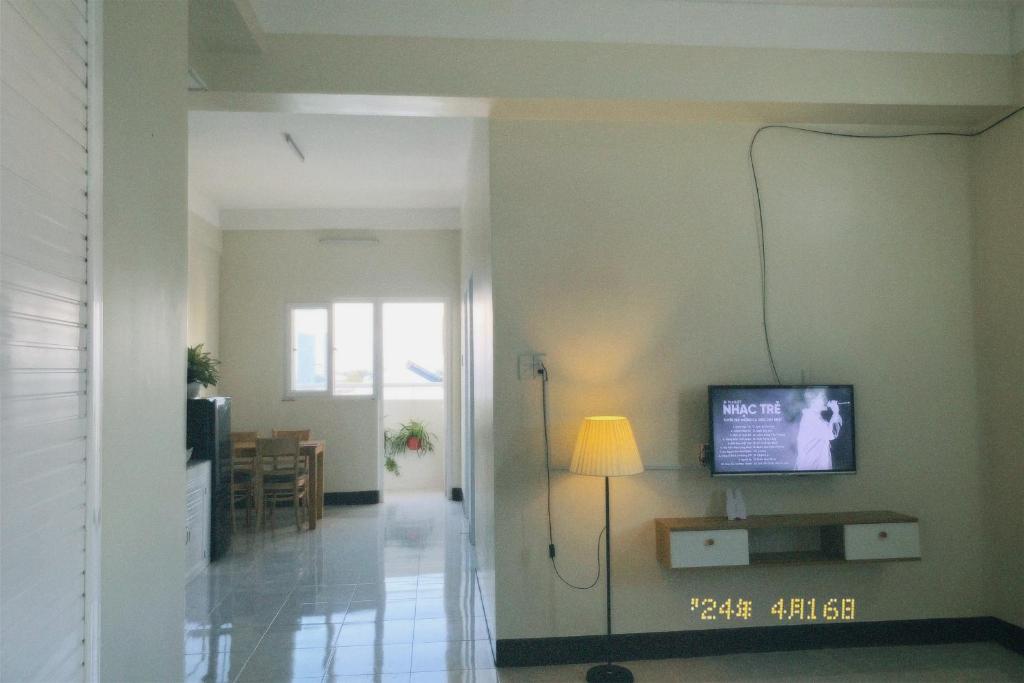 uma sala de estar com televisão na parede em Nhà Tú Homestay em Thôn Mỹ Phước