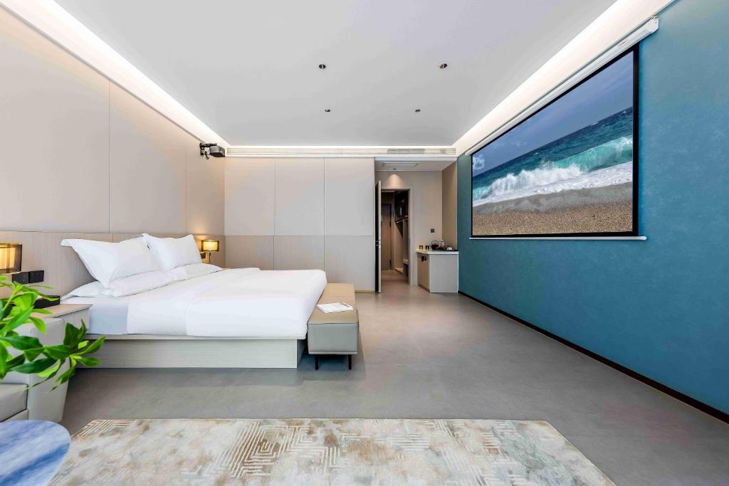 una camera con un letto bianco e una parete blu di Kunming Yuxi Hotel a Kunming
