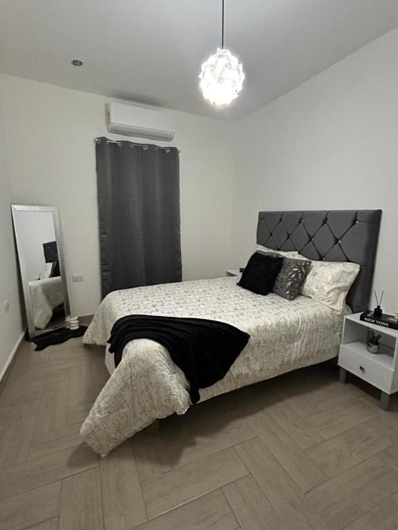 um quarto branco com uma cama e um lustre em Casa 4 Personas, céntrica, patio amplio em Ciudad Lerdo