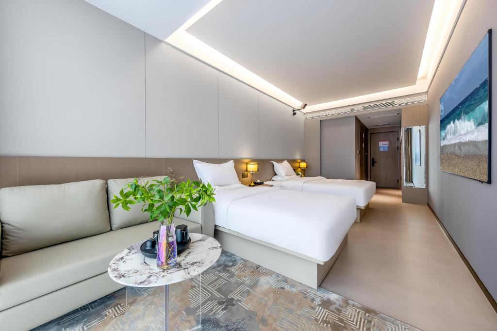 un soggiorno con divano e letto di Kunming Yuxi Hotel a Kunming