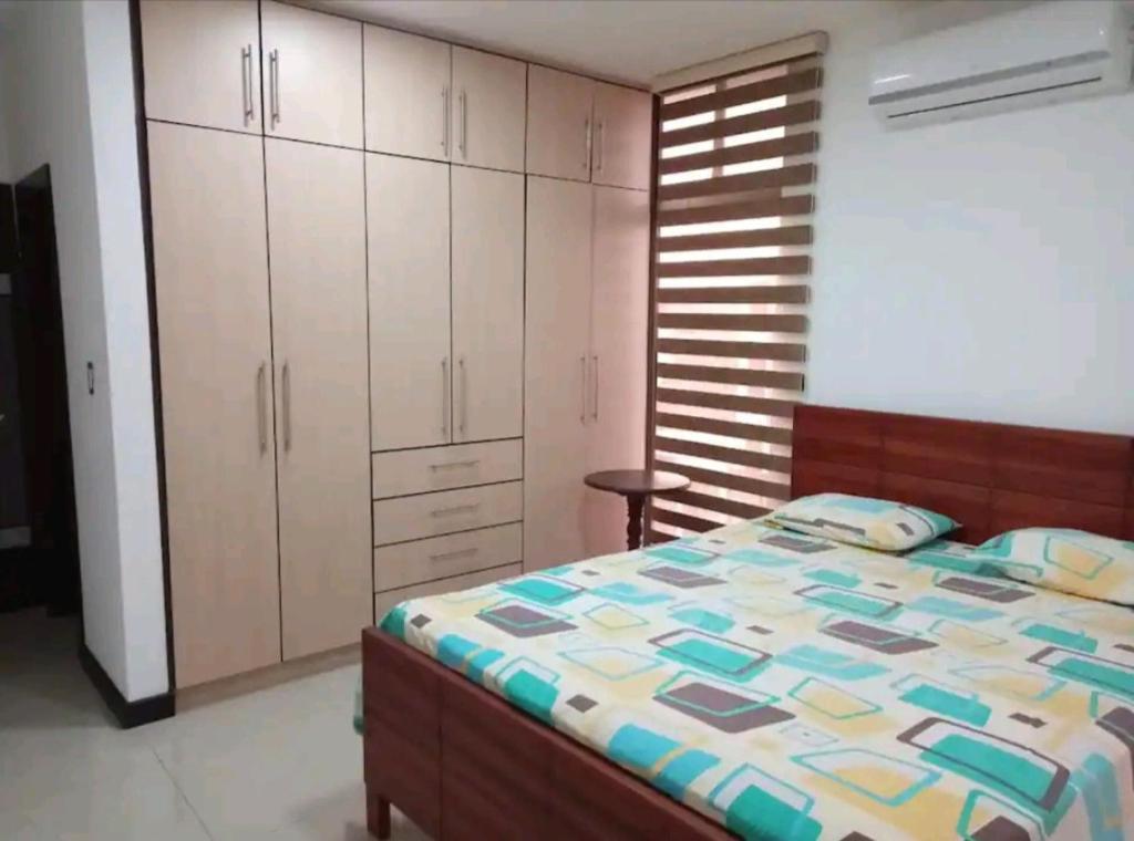 a bedroom with a bed and white cabinets at Sky Blue Apartments in Manta