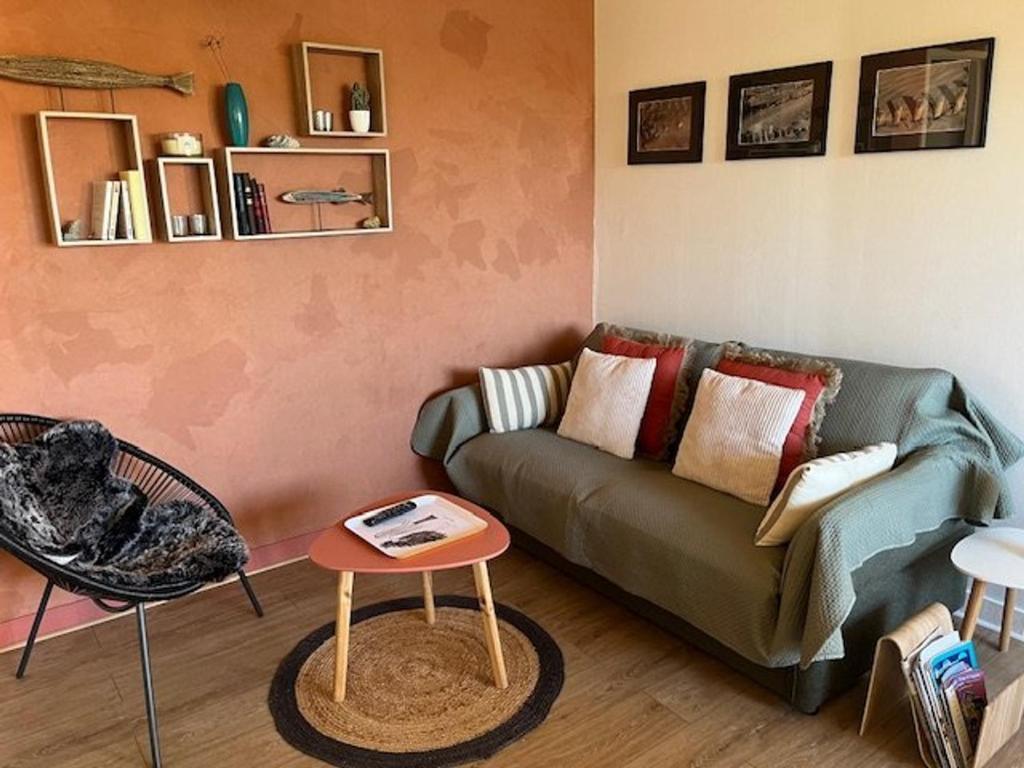 un salon avec un canapé et une table dans l'établissement Charmant T2 rénové, parking privé, proche plage et commerces, idéal déplacement à pied - FR-1-749-56, au Cap d'Agde