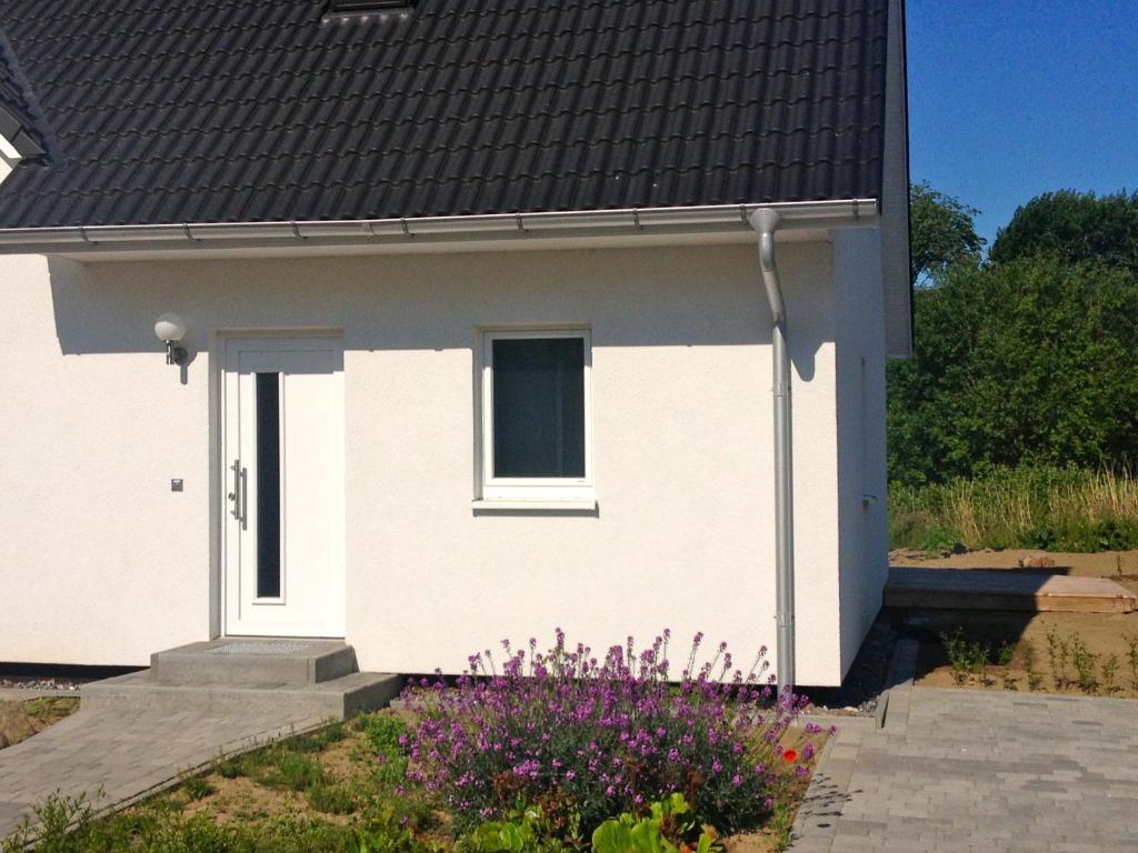 una casa blanca con una ventana y algunas flores en Ferienwohnung in Patzig auf Rügen, en Patzig
