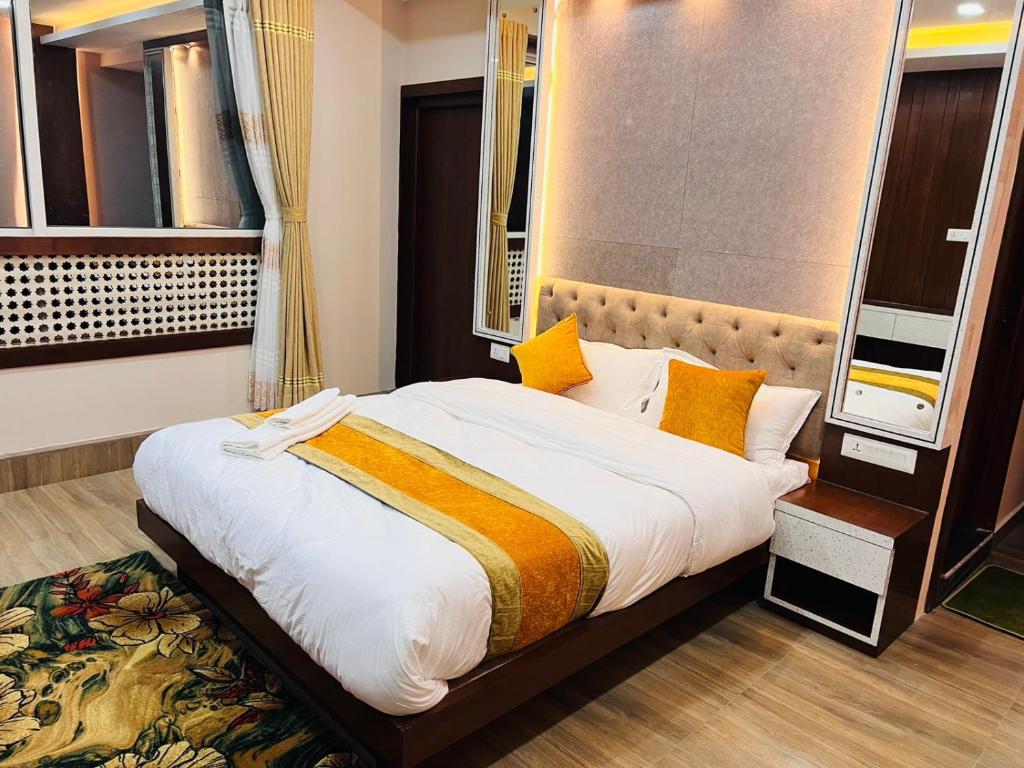 a bedroom with a large bed with yellow pillows at Hotel Nagarjun Palace in Kathmandu