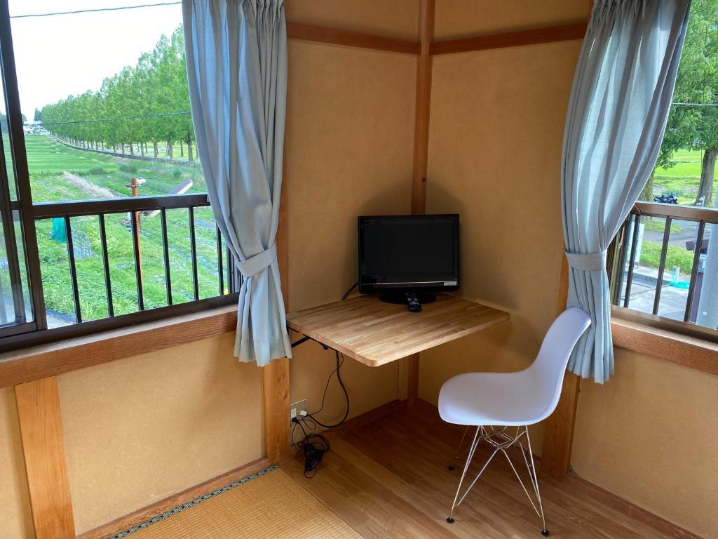 um quarto com uma secretária, uma televisão e uma janela em Makino Kogen 123 Building / Vacation STAY 79154 em Kaizu