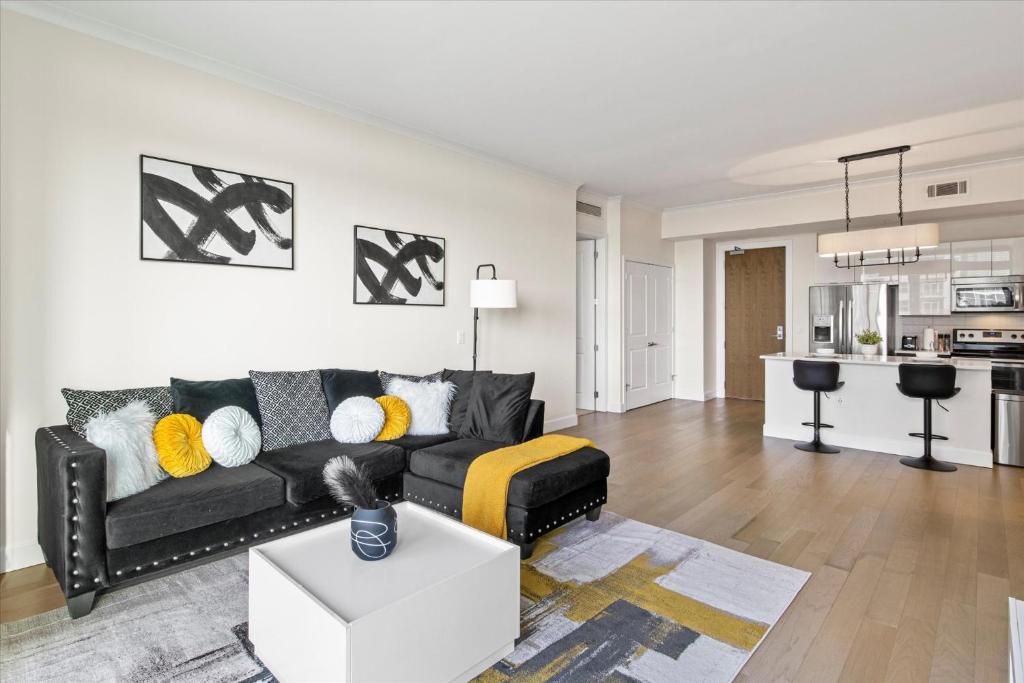 a living room with a black couch and a kitchen at Luxury Living In Buckhead in Atlanta