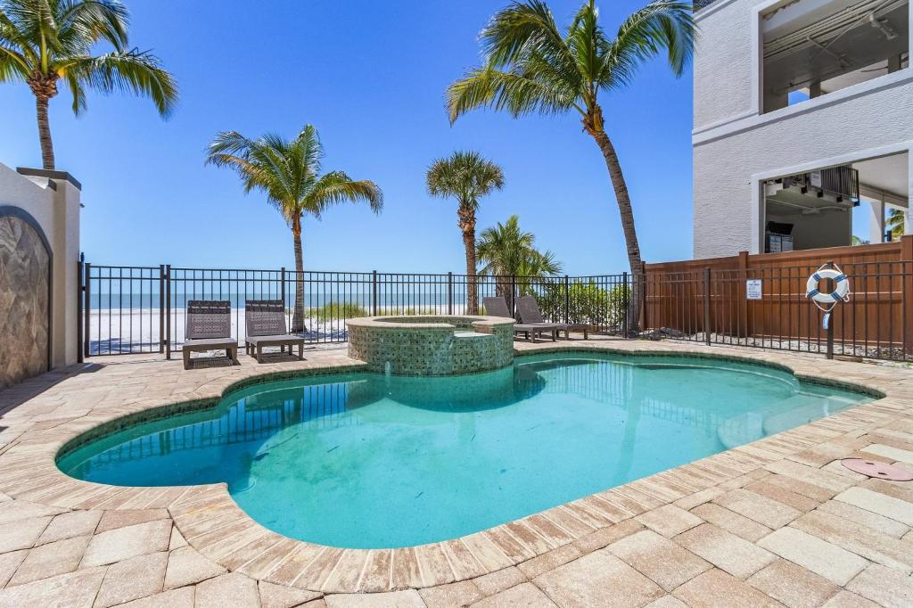 フォートマイヤーズビーチにある3132 Estero Blvd homeの噴水とヤシの木があるスイミングプール