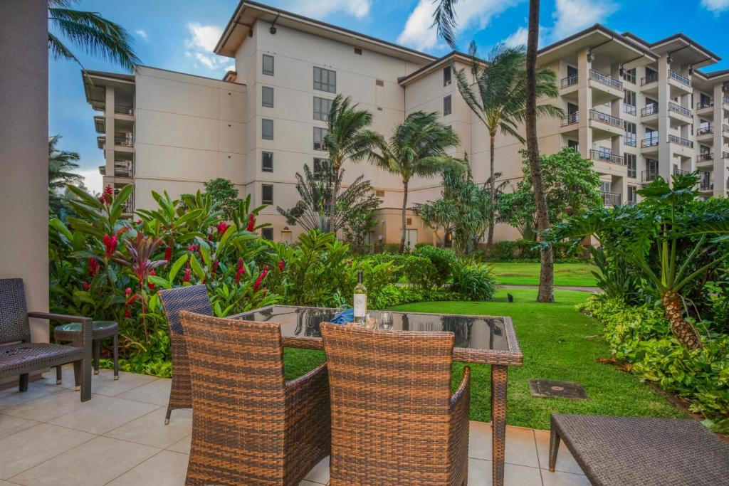 a patio with a table and chairs in front of a building at KBM Resorts: Honua Kai HKH-114 1Bd w Rental Car in Kaanapali