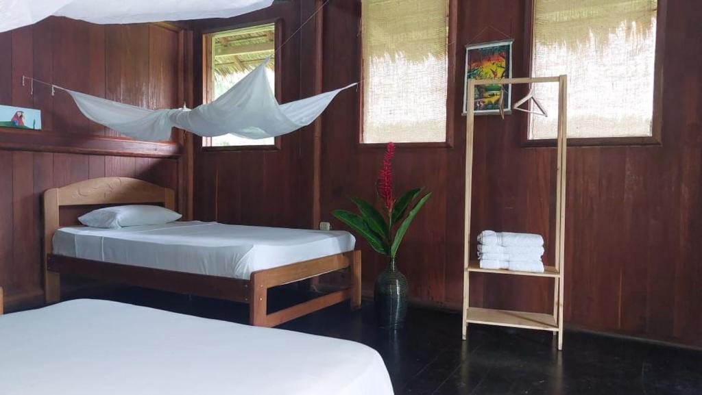 a bedroom with two beds and a table at River Point Hostel in Puerto Maldonado