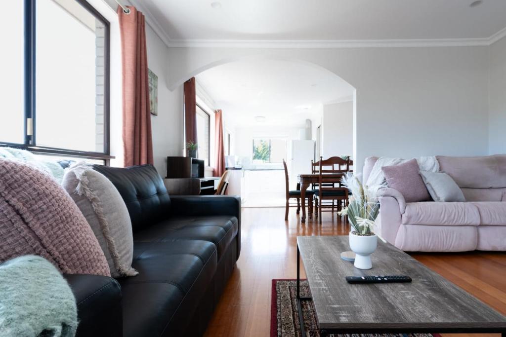 uma sala de estar com um sofá de couro preto e uma mesa em Homely Hideaway with Parking & WiFi em Alanvale