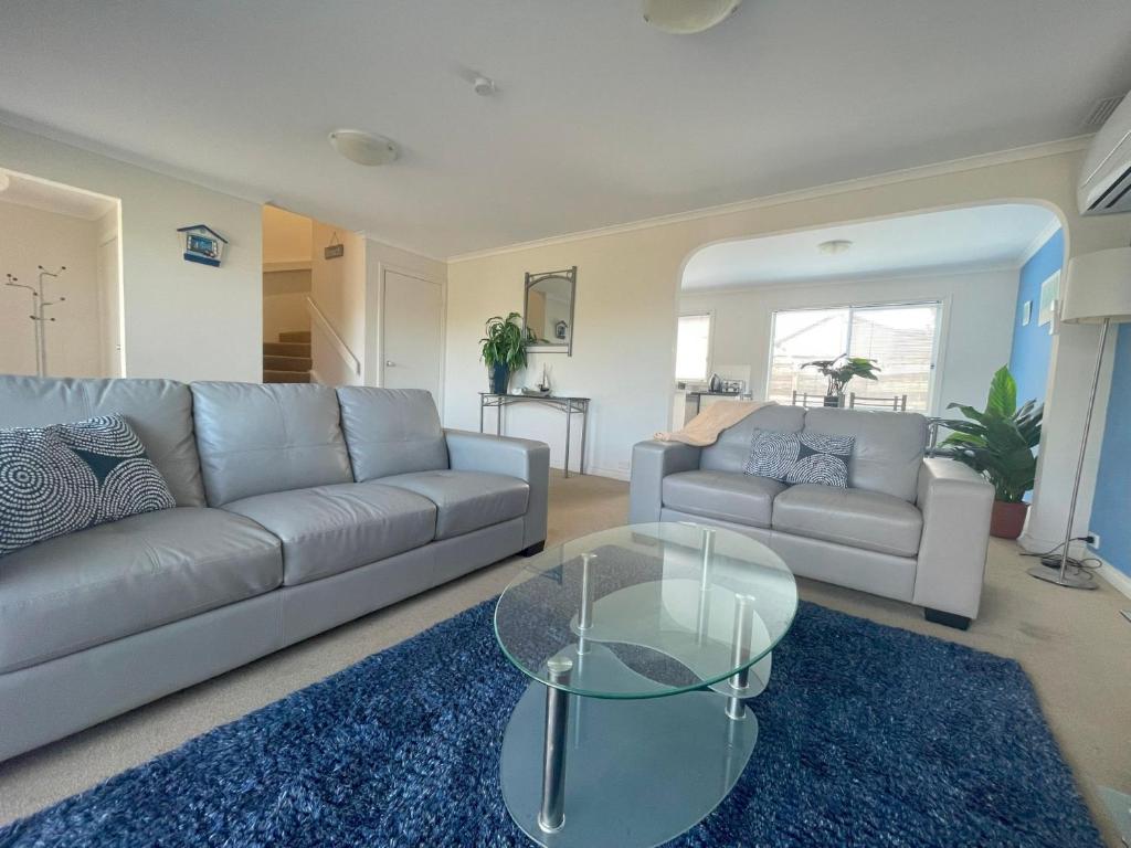 sala de estar con sofá y mesa de cristal en The Esplanade 4 en Inverloch