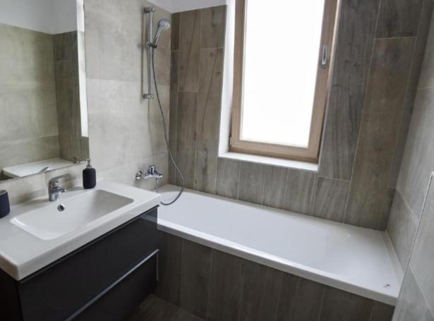 bagno con lavandino, vasca e finestra di Apartament de lux Bacău a Bacău