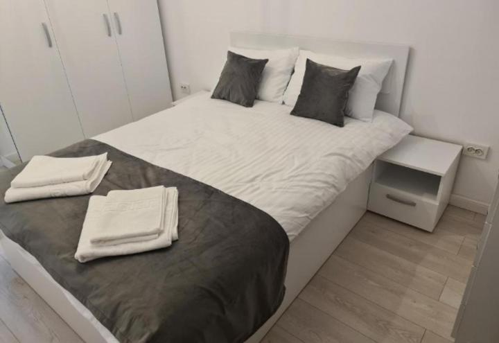 Apartament de lux Bacău في باكاو: سرير ابيض كبير عليه مناشف في غرفه