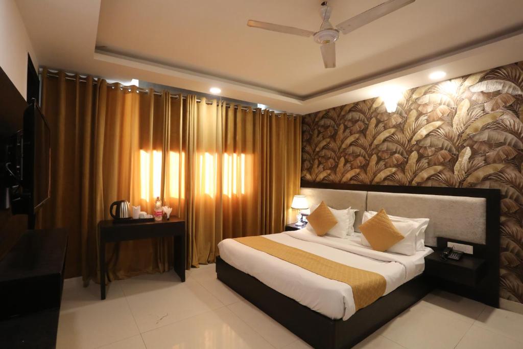 a bedroom with a large bed with a wall mural at Hotel Aashiyana Palace Just 4Km Away From Delhi Airport in New Delhi