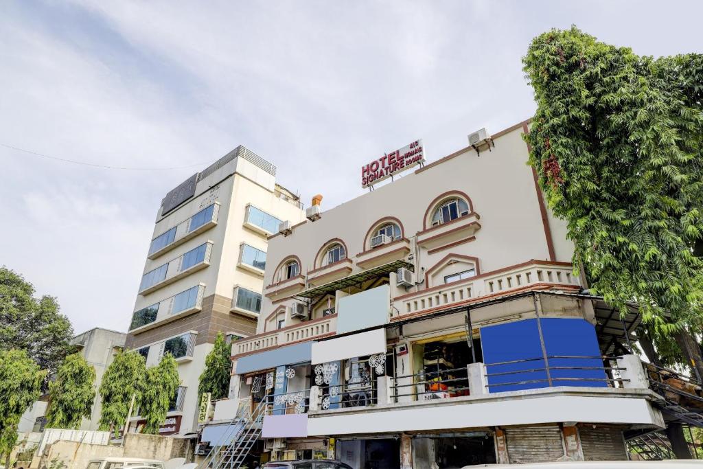 un edificio con un albero sopra di OYO Hotel Signature a Ahmedabad