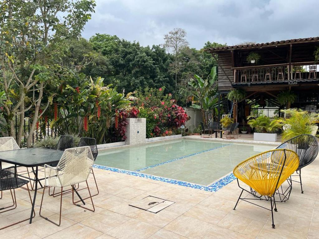 卡拉爾卡的住宿－Kai Hotel Campestre，一个带桌椅的庭院和一个游泳池