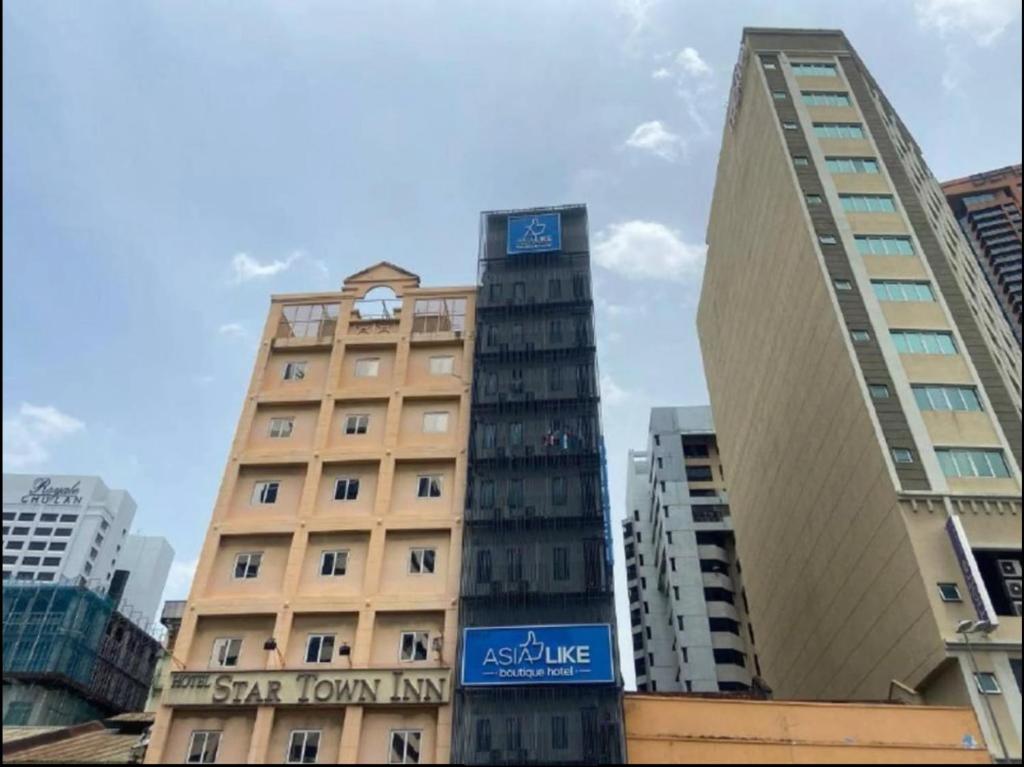 um edifício alto com um relógio em cima em Asia Like Boutique Hotel em Kuala Lumpur