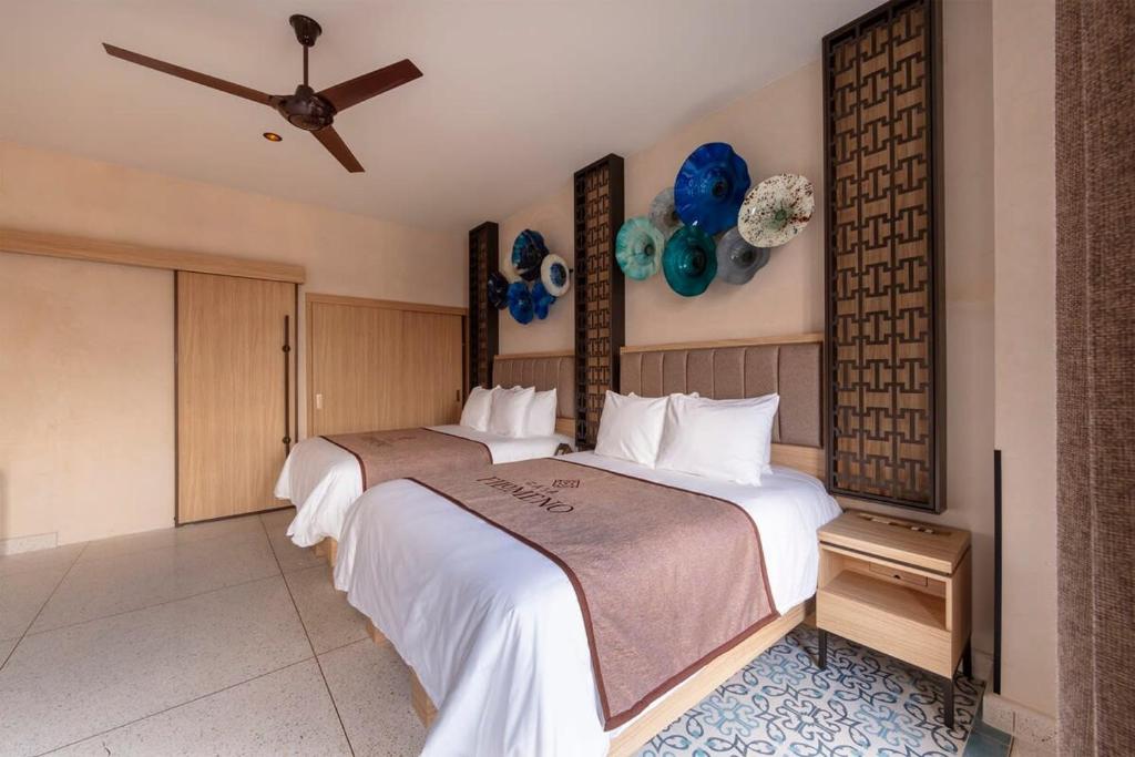 een slaapkamer met 2 bedden en een plafondventilator bij Suite 2 camas y sofa cama in Mexico-Stad