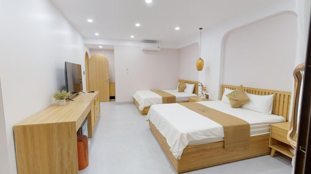 a hotel room with two beds and a television at Secret Garden FLC Sầm Sơn in Sầm Sơn