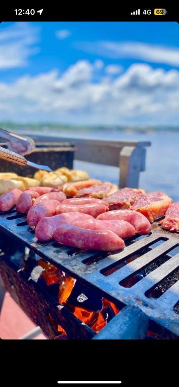 a bunch of sausages and other foods on a grill at Casa flutuante - Manaus Amazonas in Manaus