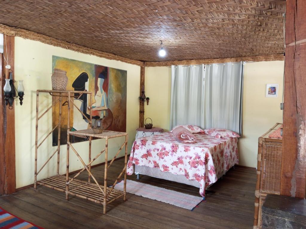 a bedroom with a bed and a table in a room at Fazenda Mundo Novo in Divisa