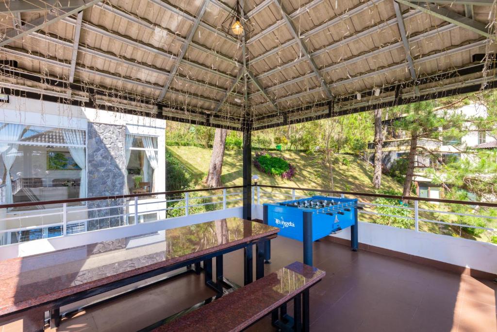 ein Balkon mit zwei Tischen und Blick auf Bäume in der Unterkunft Biệt Thự Lan Anh Đà Lạt in Da Lat