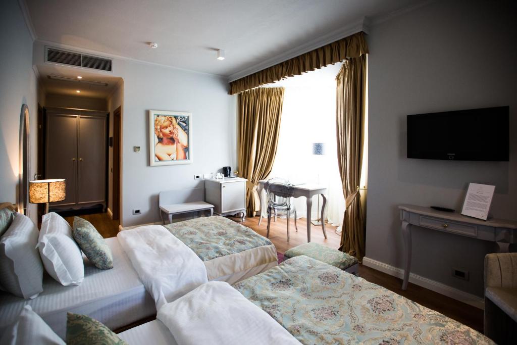 a hotel room with a bed and a desk and a television at Classic Hotel in Tirana
