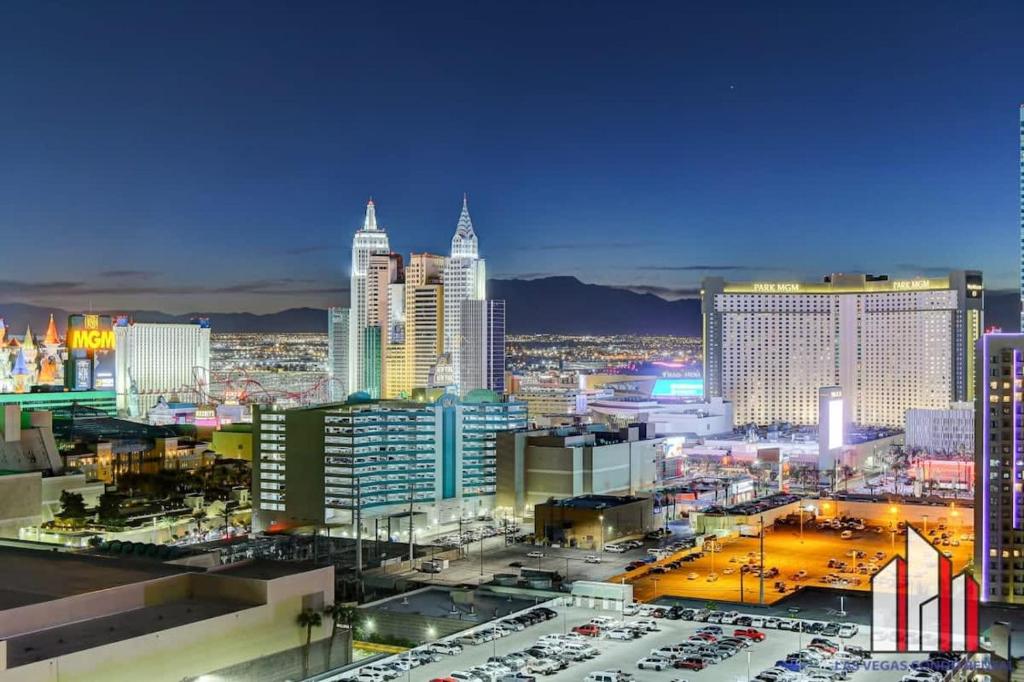 un horizon de ville la nuit avec des voitures garées dans un parking dans l'établissement MGM Signature-33-709 F1 Track & Strip View Balcony, à Las Vegas
