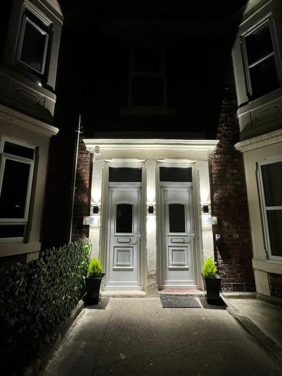 a white front door of a house at night at Luxury Ensuite Rooms @ Kingsley Terrace in Newcastle upon Tyne