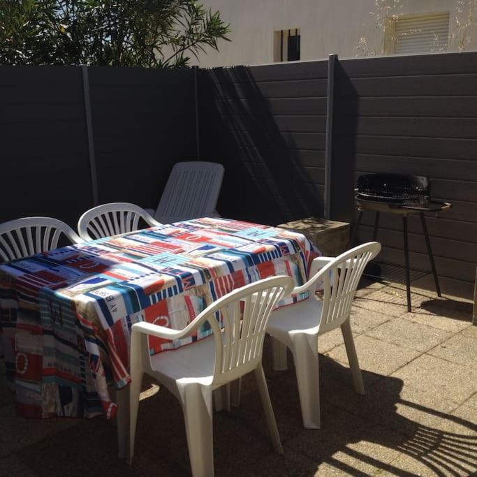 - une table avec 4 chaises et une couverture dans l'établissement Charmante maison à 500m de la plage Rémigeasse, à Dolus-d'Oléron