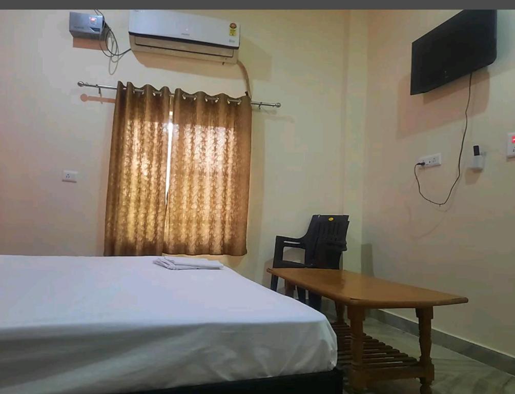 a room with a bed and a table and a window at Sky Inn paying guest house in Varanasi