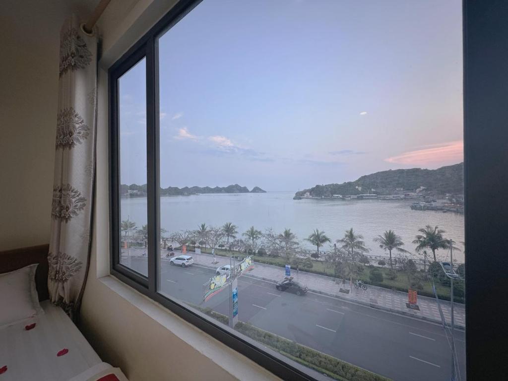 a room with a window with a view of the water at GEM HOSTEL in Cat Ba