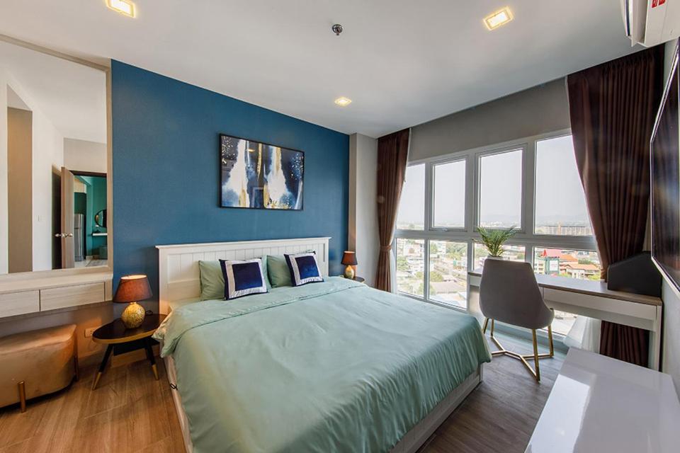 1 dormitorio con 1 cama grande y pared azul en Prio signature condo, en Chiang Mai