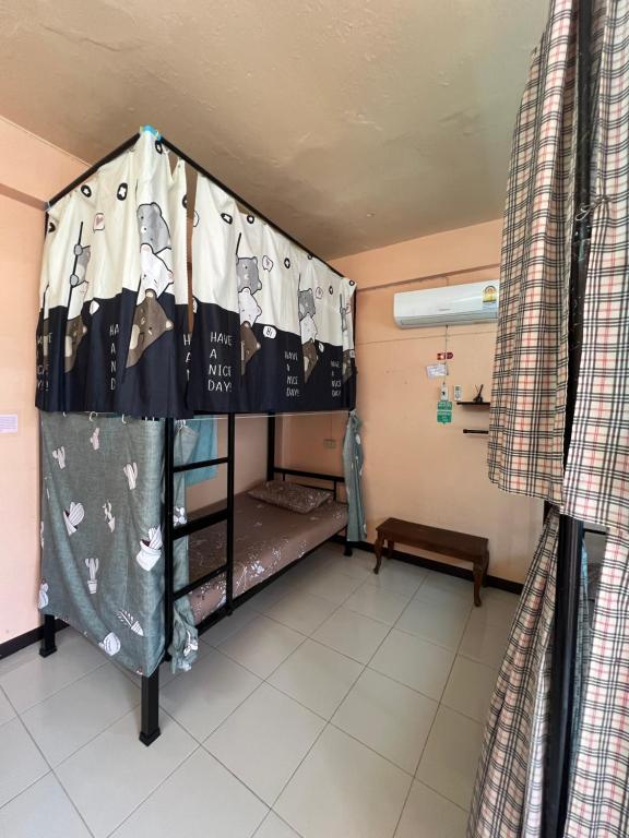 a room with a bunk bed in a hospital at Karma Home Hostel in Phitsanulok
