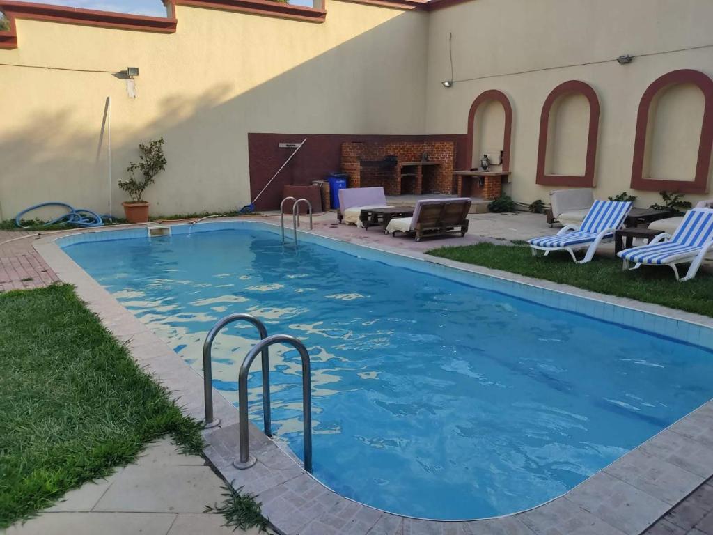uma piscina com água azul num quintal em Red Roof Seaview Hotel em Baku