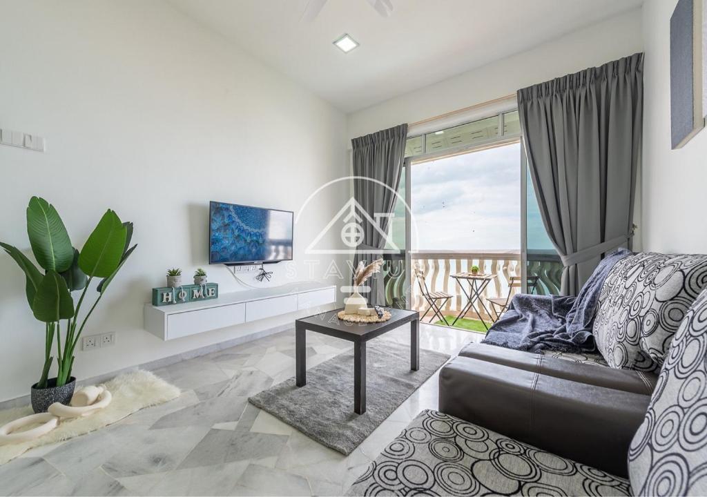 a living room with a couch and a table at (10Pax) 3BR Glory Beach Resort Seaview in Port Dickson